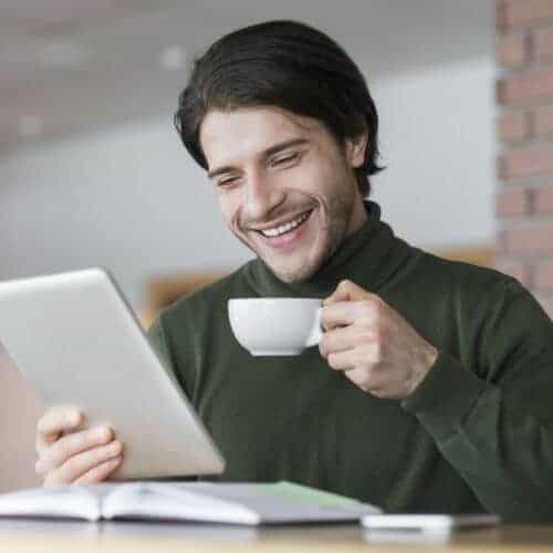 young successful businessman checking emails while having morning coffee e1631573561115 Buro